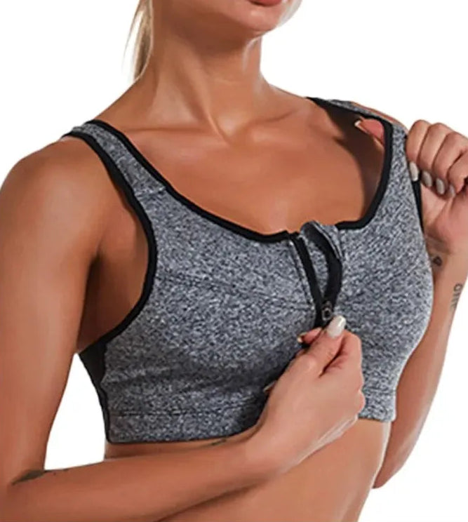 Gray sports bra with black trim worn by a person on a white background