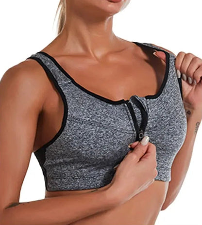 Gray sports bra with black trim worn by a person on a white background