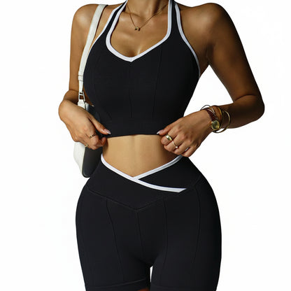 Person wearing a black sports bra and leggings with white accents