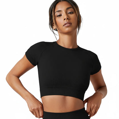 Woman wearing a black crop top against a plain background