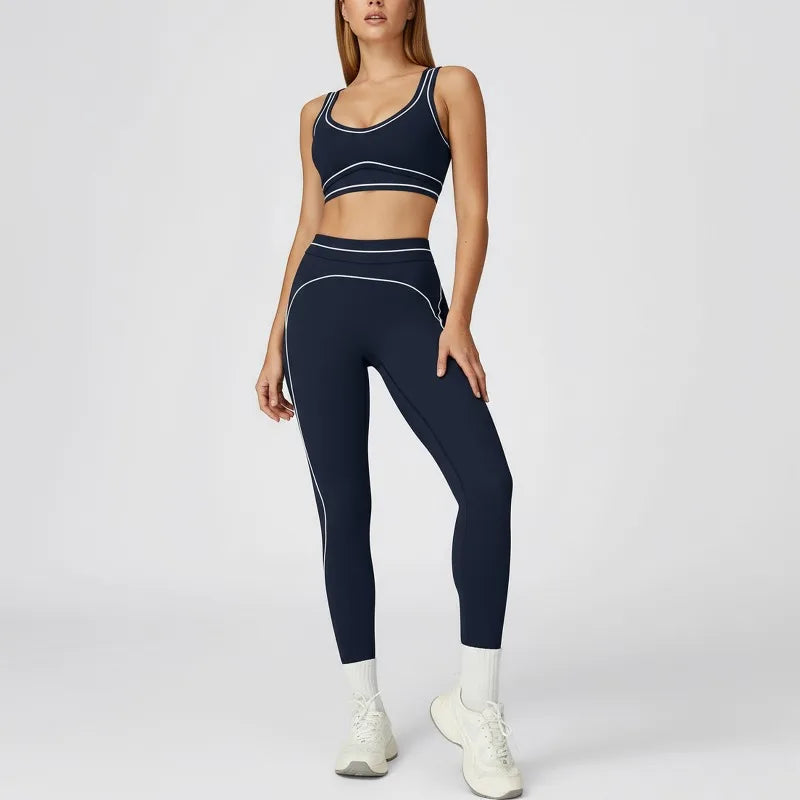 Person wearing a navy blue sports bra and leggings set on a white background