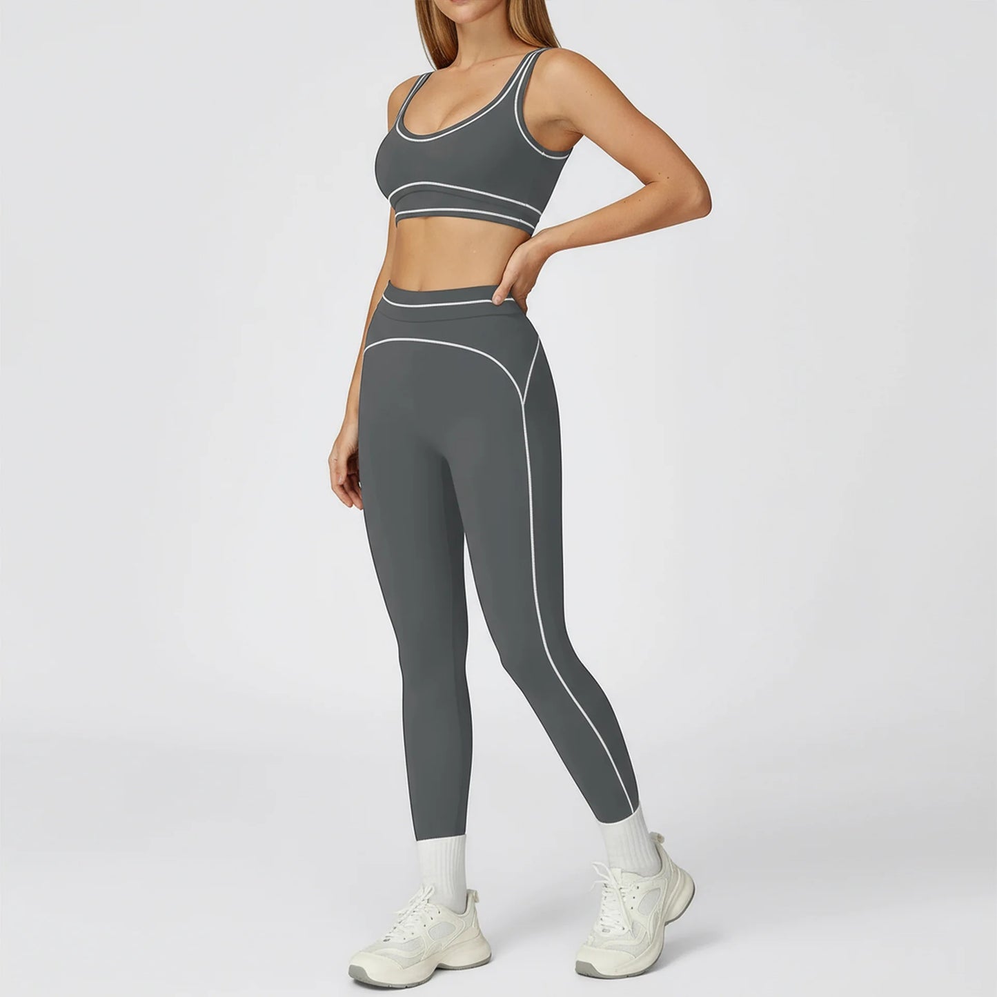 Person wearing a gray sports bra and leggings set on a white background