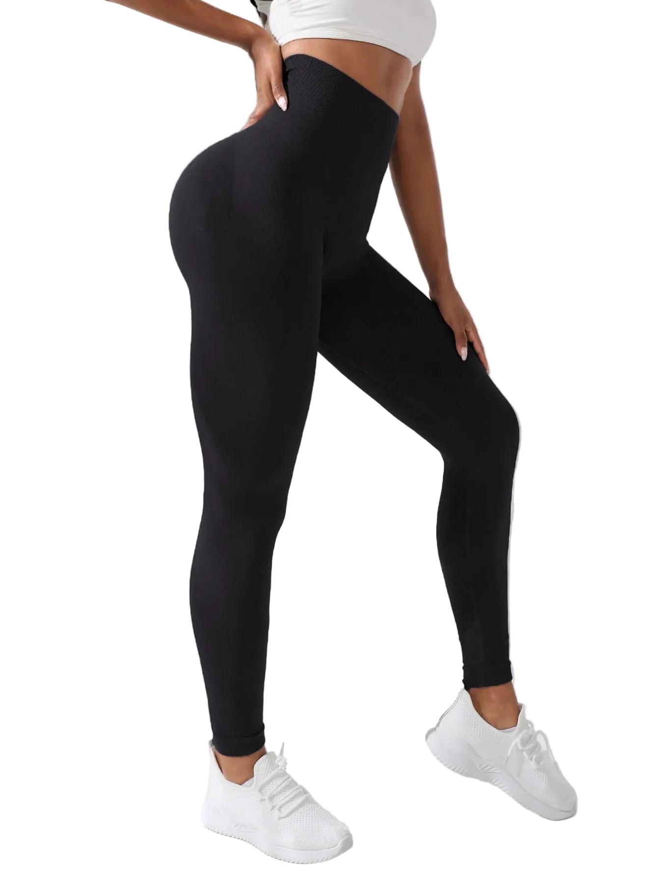 Person wearing black leggings and white sneakers against a white background