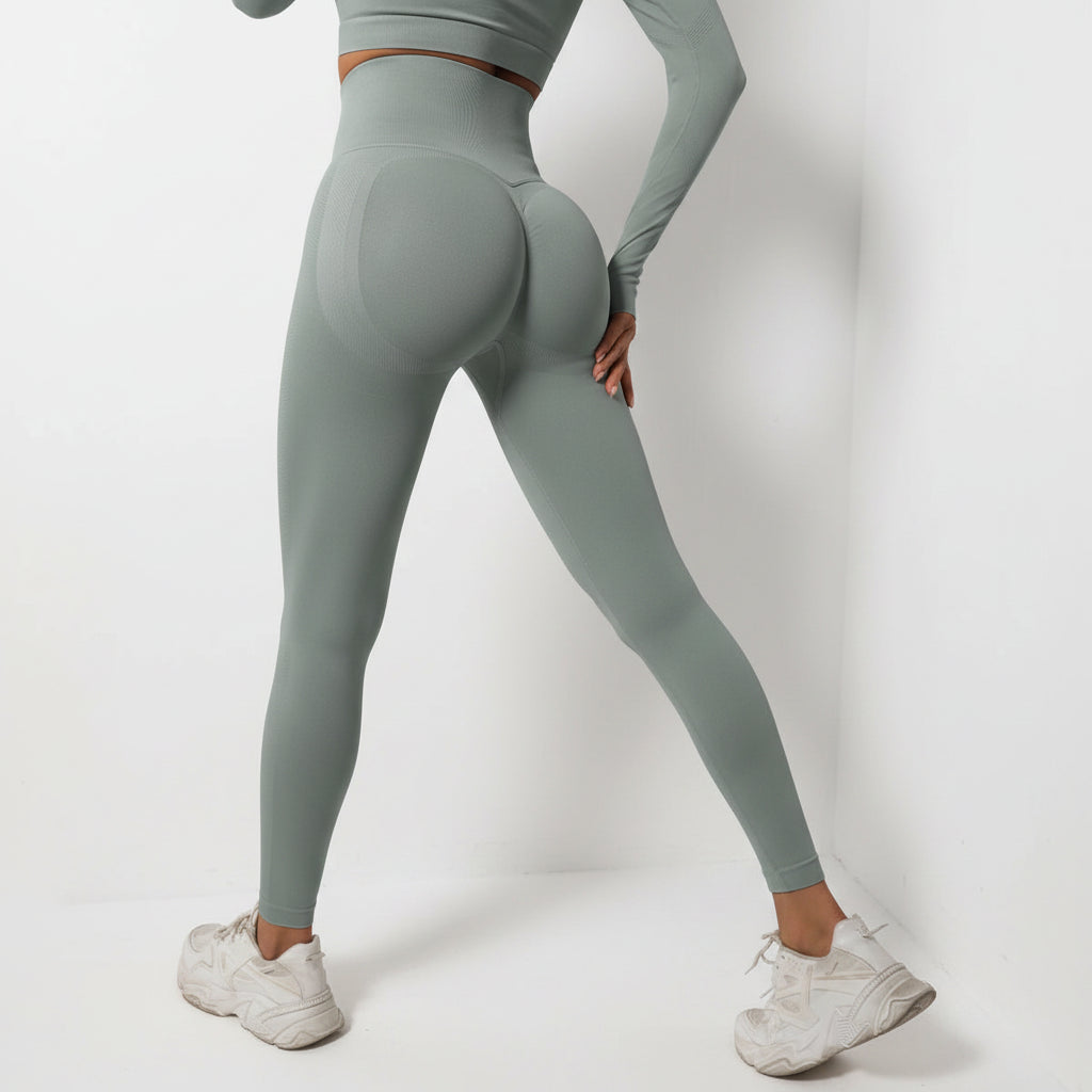 Person wearing gray leggings and a cropped top